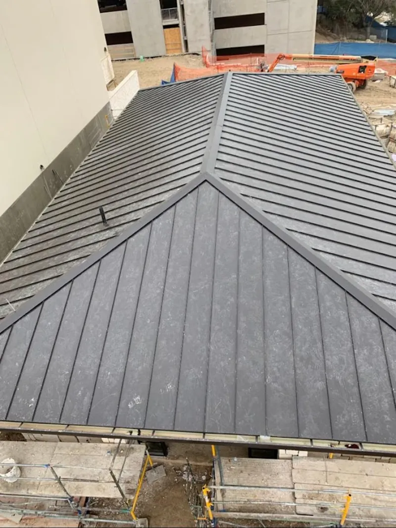 Commercial metal roof construction with crane equipment in Azle